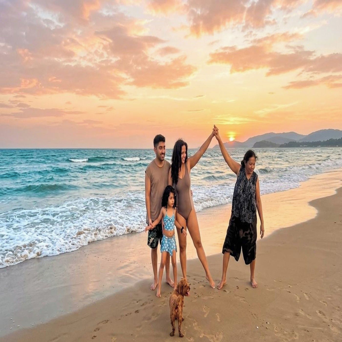 A family on a beach with a sunset in the background.