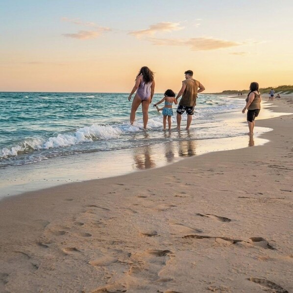A beach scene with a family walking along the shore.