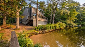 A house with a deck and a dock extending into a calm body of water, surrounded by trees. - Camp Come Again on Silver Lake–Pet-Friendly w/ Private Dock, Swimming & Views (Silver Lake)