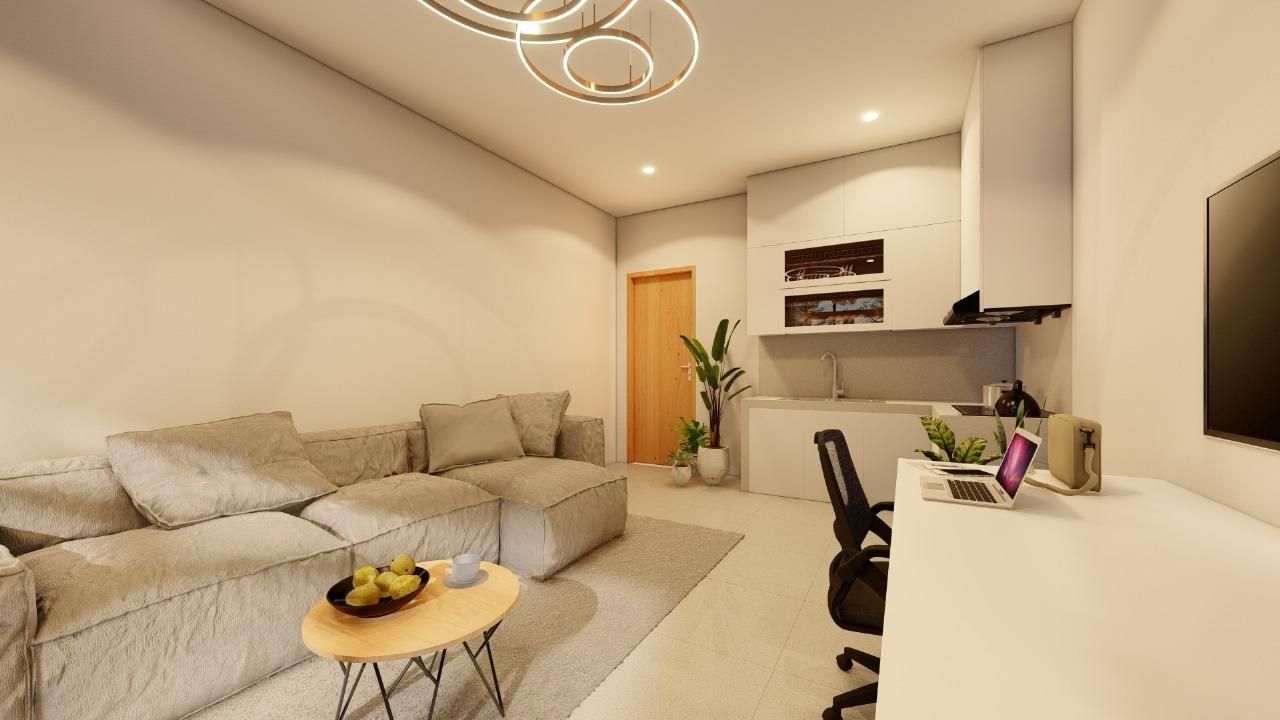Un salon moderne avec un canapé, une table basse et un ordinateur portable posé sur un bureau.