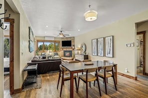 A spacious living area with a fireplace, dining table, and comfortable seating. - Steps to the Lifts | Hot Tubs, Fireplace & Shuttle (Steamboat Springs)