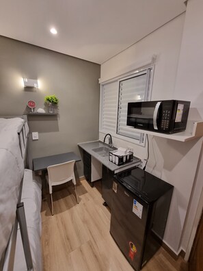 Une petite cuisine équipée comprenant un four à micro-ondes, un évier et un petit plan de travail.