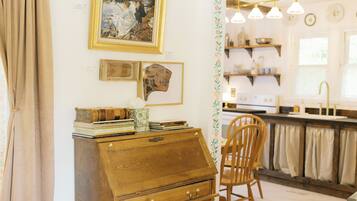 Une pièce comprenant un bureau en bois, une chaise, un tableau et une décoration faite d’une branche de cerf.