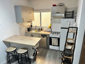 A compact kitchen with a central island, a stove, a refrigerator, and a built-in oven. - Cozy Flat. Walking distance to the beach or town centre is 4 Min (Guía de Isora)
