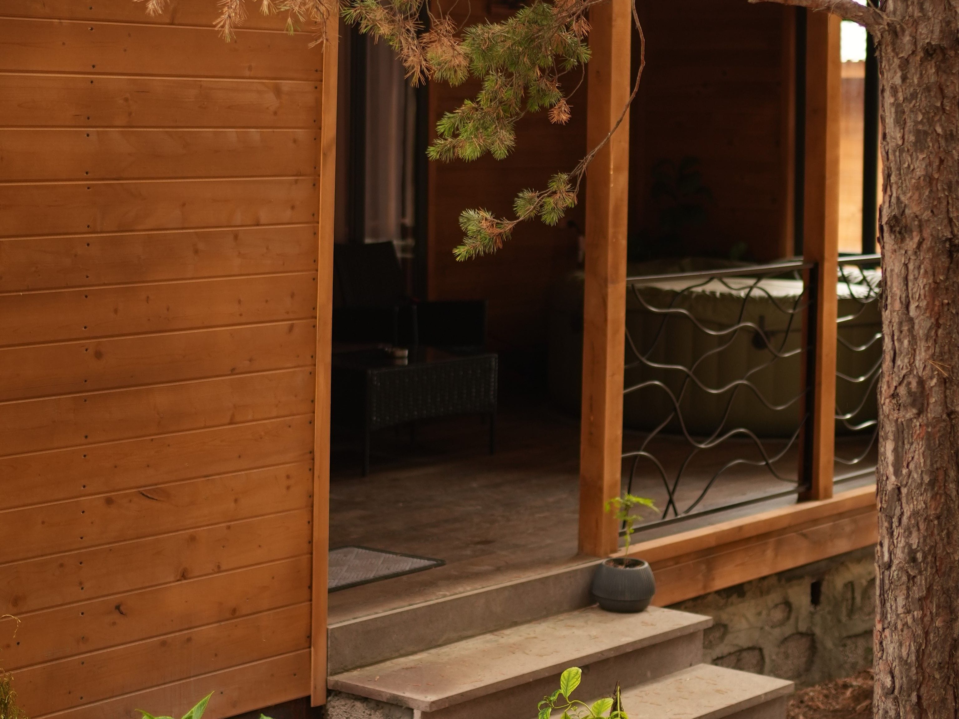 A wooden exterior with a stone staircase leading to a covered porch area.