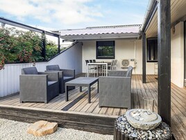 Un patio al aire libre con mobiliario de mimbre, una mesa y sillas.