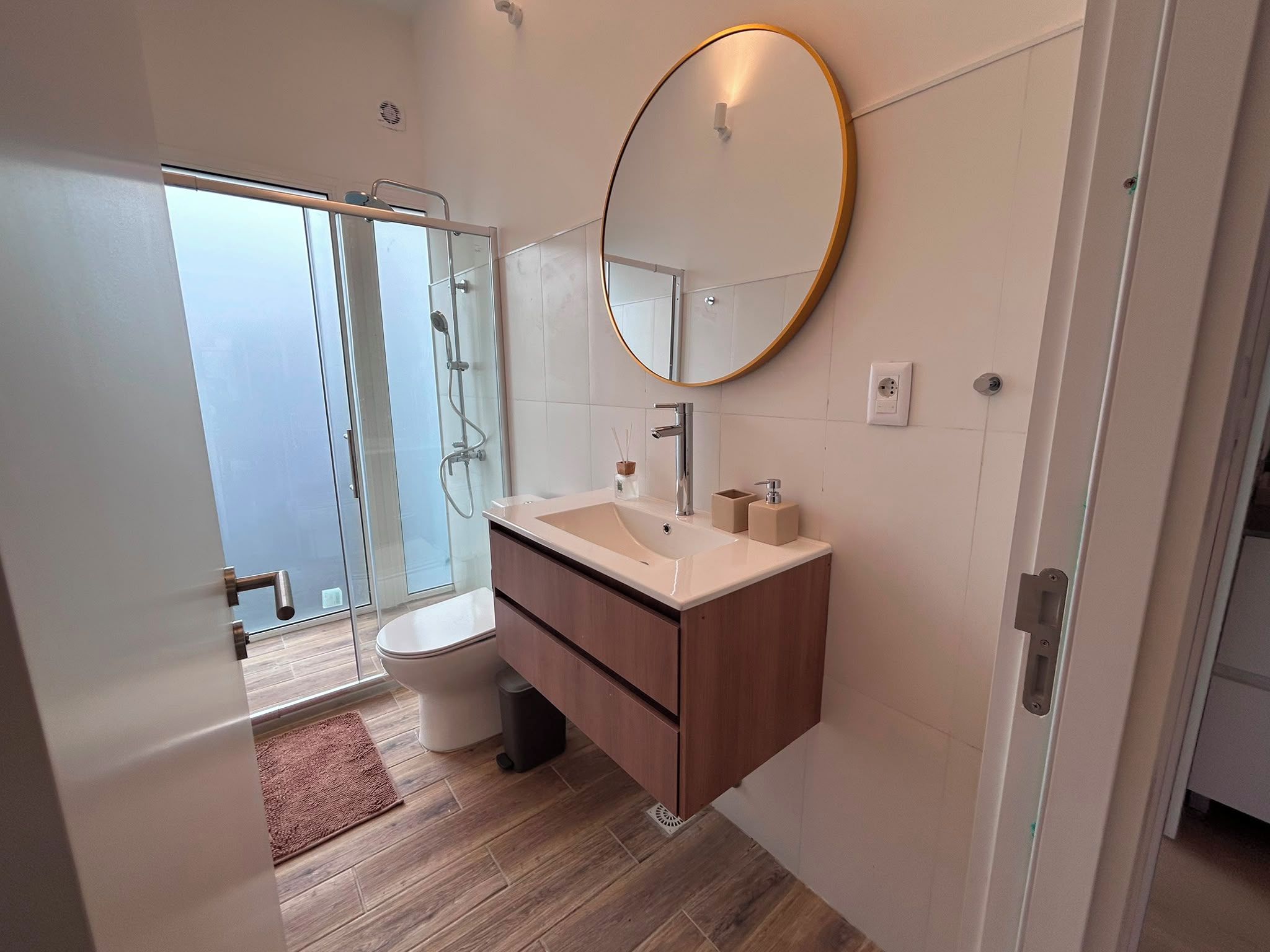 Une salle de bain moderne équipée d’une douche, de toilettes et d’un meuble-lavabo.