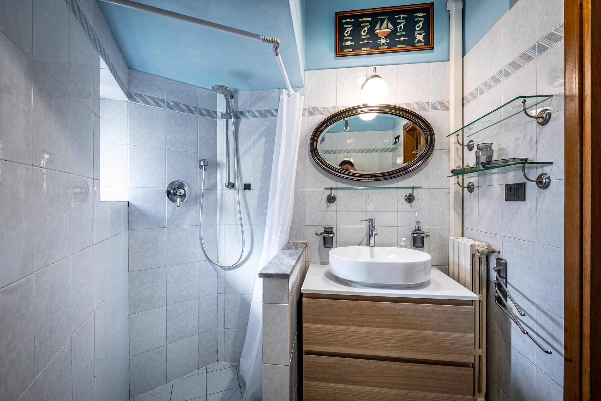 Un baño moderno con ducha, lavamanos y espejo.