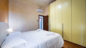 Una habitación de hotel con cama, armario y aire acondicionado.