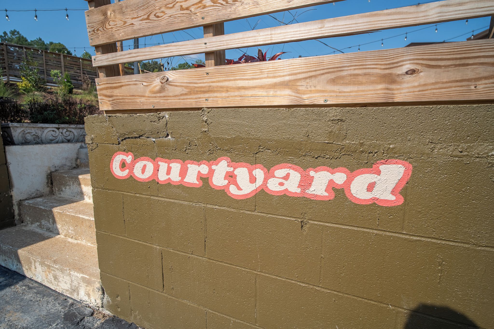 Een muur met de tekst 'Courtyard' in rode en witte letters.