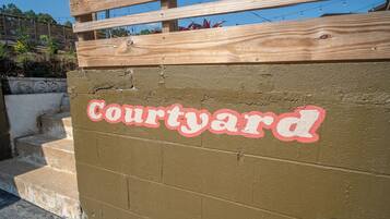 Een muur met de tekst 'Courtyard' in rode en witte letters.