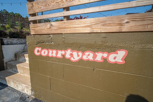 Una pared con la palabra 'Courtyard' pintada en letras rojas y blancas.
