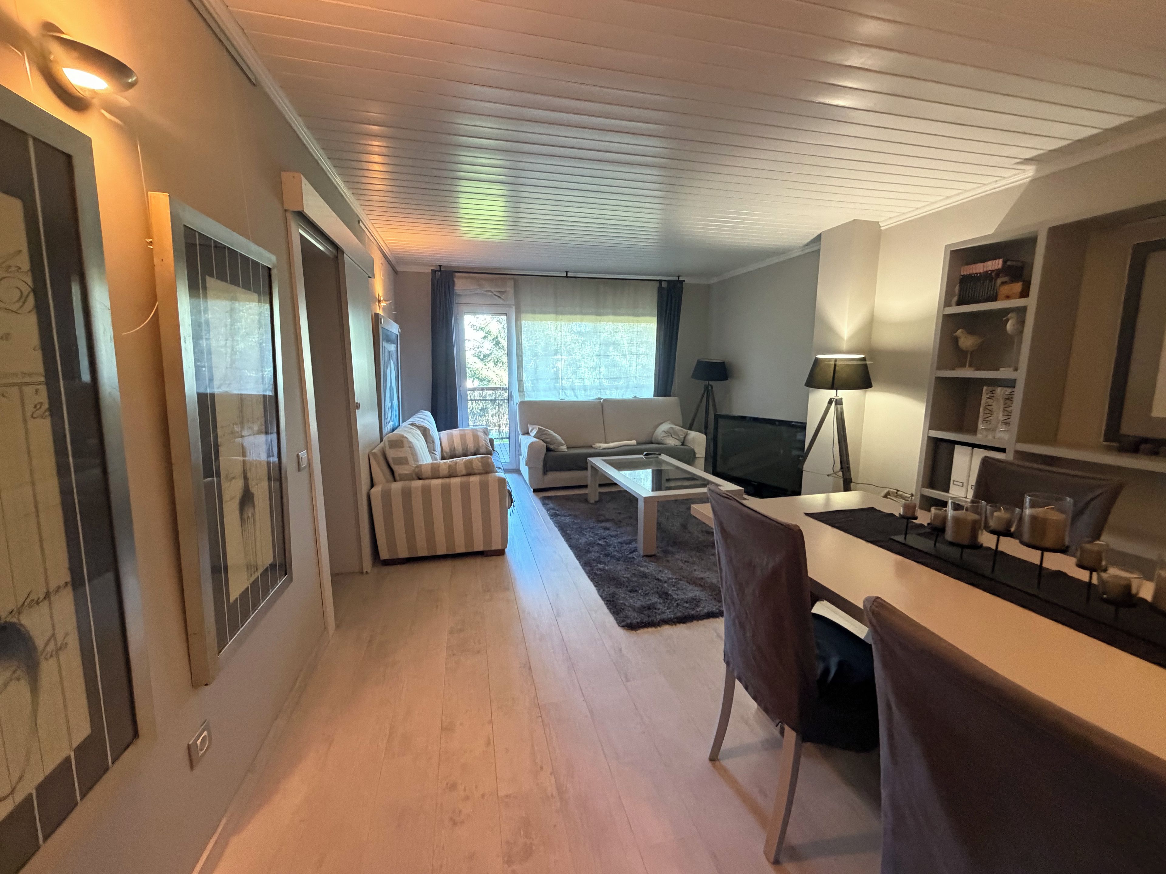 Una sala de estar moderna con un sofá, una mesa de centro y un televisor.
