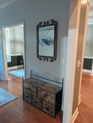 A room with a wooden bench, a decorative mirror, and a patterned rug. - Gorgeous 4-bedroom home with pool. 5 min from Lake Murray (Lexington)