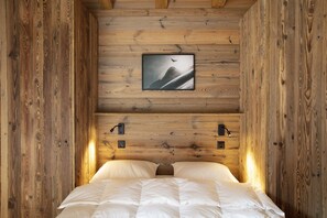 A wooden cabin room with a bed, a framed picture on the wall, and two wall-mounted lights. - Polaris 1 006 - LUXE & SKI LIFT apartment for 6 people (Zinal)