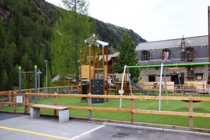 A playground with a wooden fence and a bench in front. - Polaris 1 006 - LUXE & SKI LIFT apartment for 6 people (Zinal)
