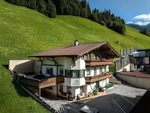 A two-story building with a balcony, a sign reading 'Landhaus Gurin,' and a parking area in front.
