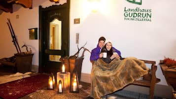 A cozy room with a fireplace, candles, and a sign indicating the location as Landhaus Gudrun.
