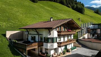 A two-story building with a balcony, a sign reading 'Landhaus Gurin,' and a parking area in front.