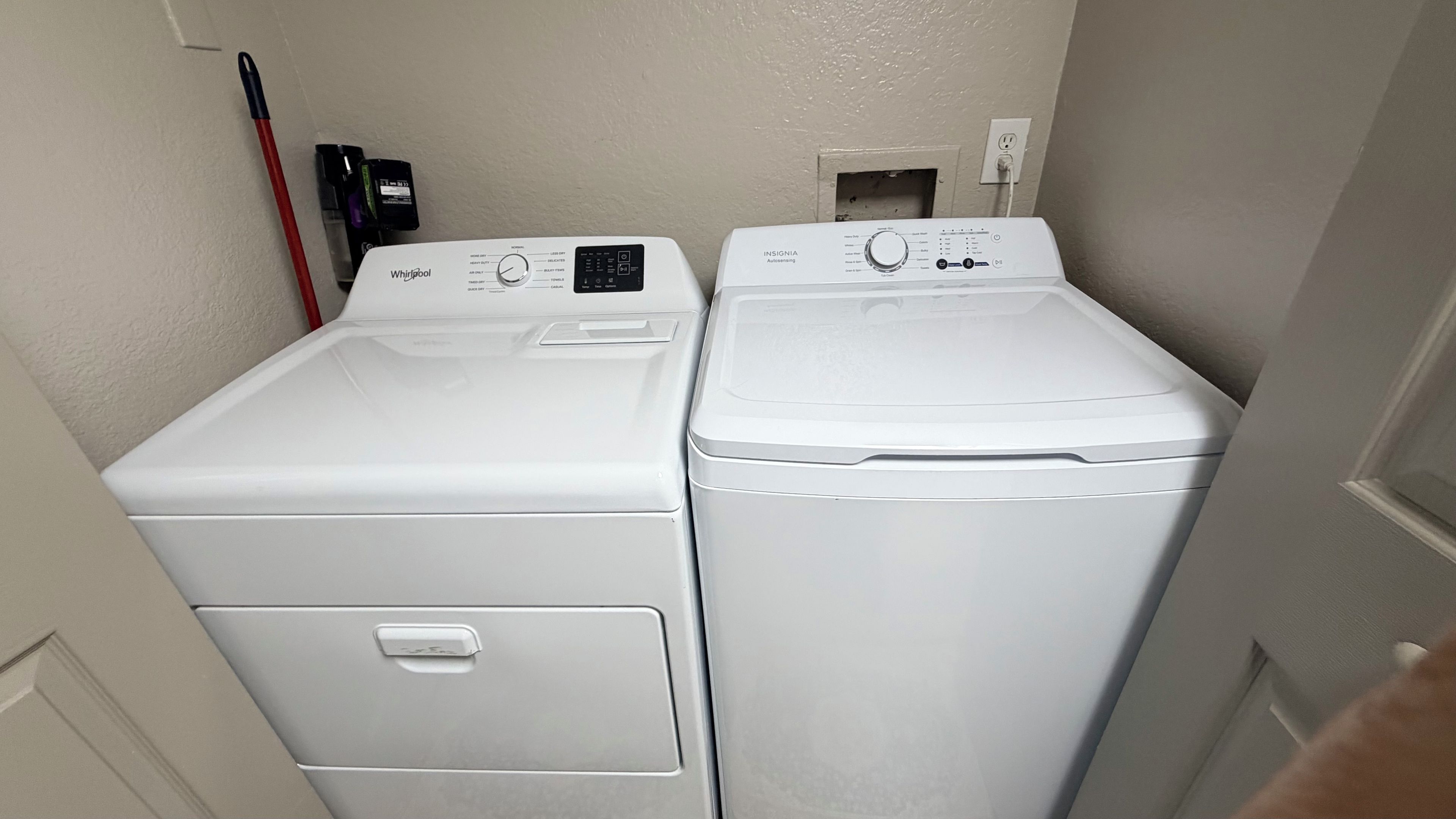 Un cuarto de lavandería con dos lavadoras Whirlpool de carga frontal y una secadora Whirlpool.