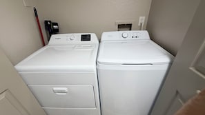 Uma lavanderia com duas máquinas de lavar Whirlpool de carregamento frontal e uma secadora Whirlpool.