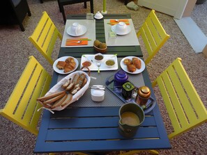 Una mesa lista para el desayuno con pan, croissants y una bebida.