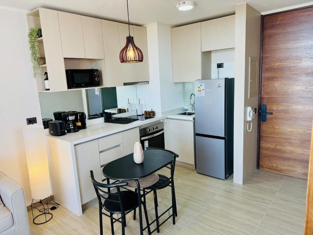 A compact kitchen with a dining area, a microwave, a coffee maker, and a refrigerator.
