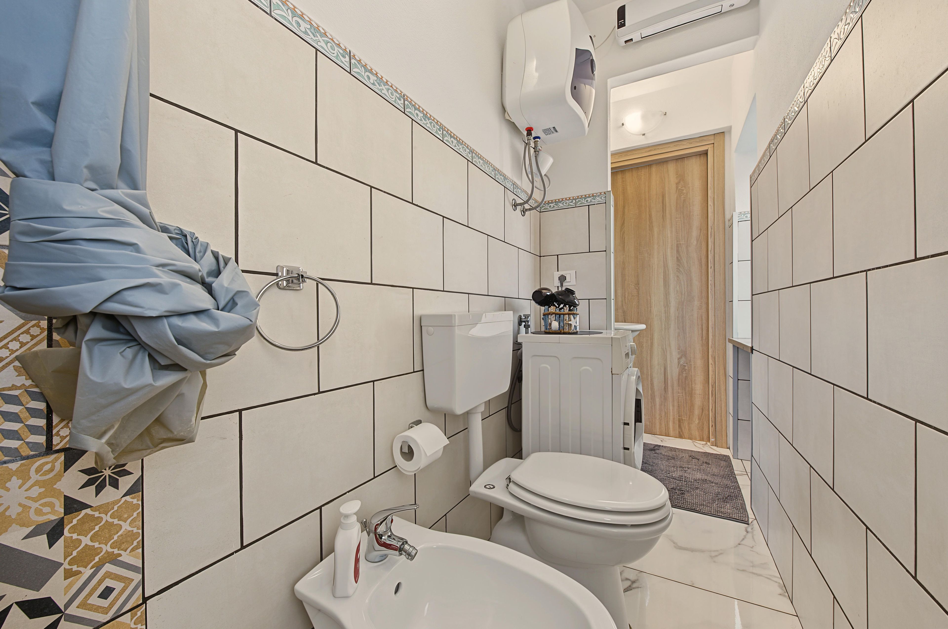 A bathroom with a toilet, sink, and shower area.