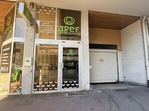 A storefront with a glass door and windows, a sign with the logo 'aper', and a no parking sign on the right. - 42-square-meter apartment, 1 bedroom, downtown, parking space (Aix-les-Bains)
