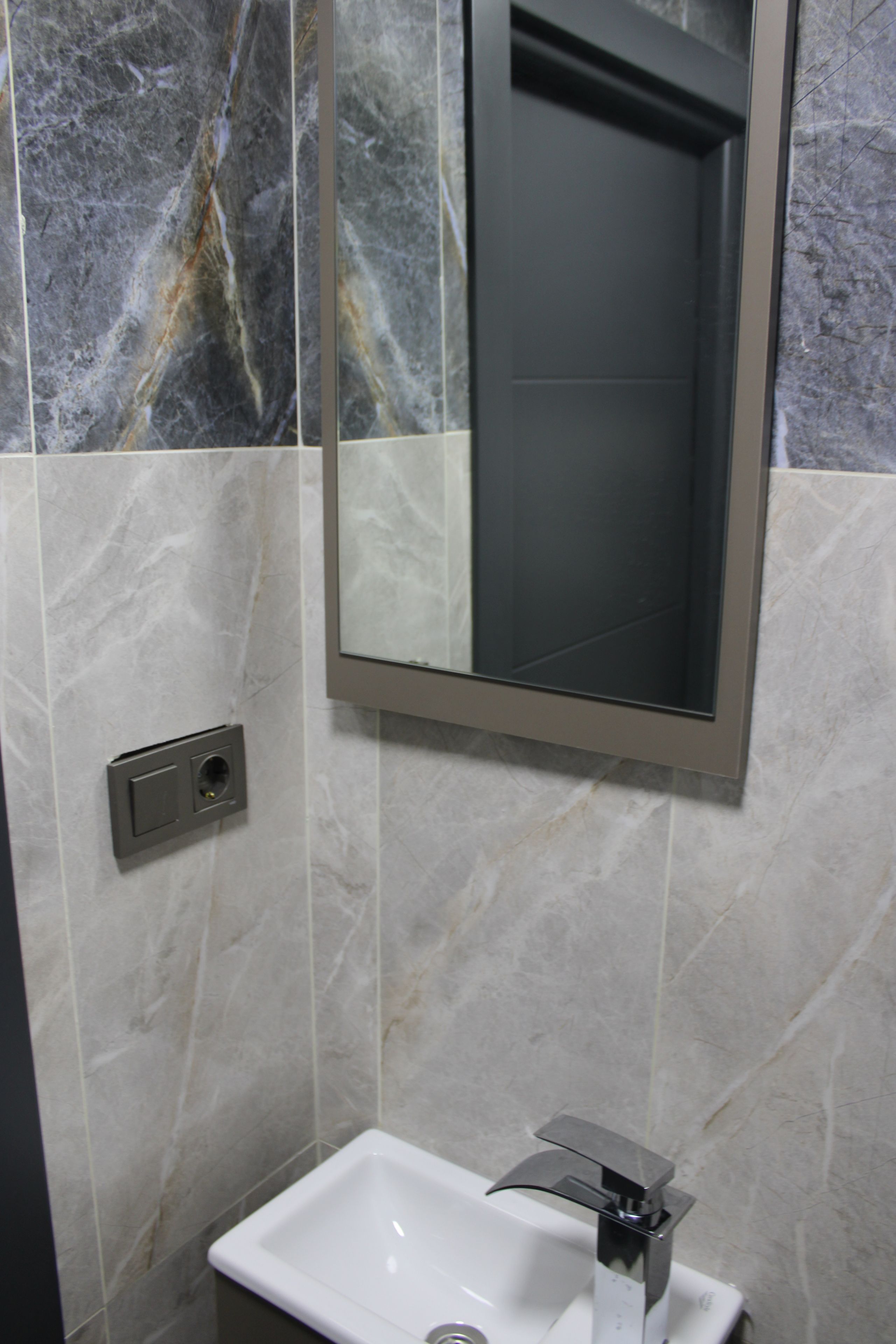 A bathroom with a white sink, a mirror, and a shower enclosure.