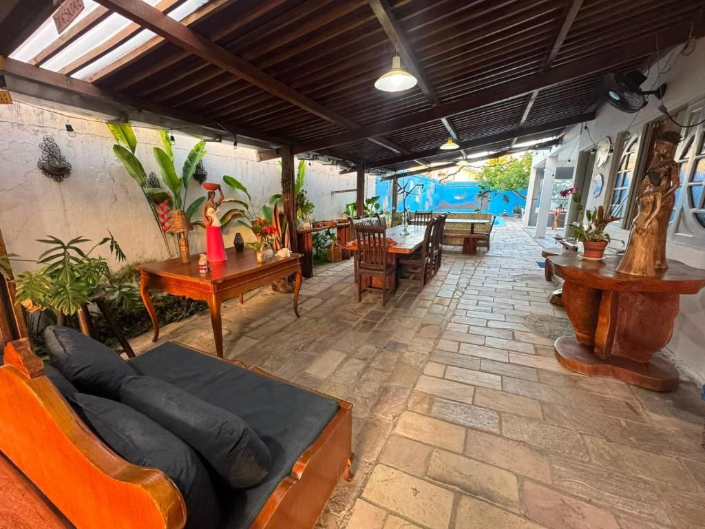 Un patio al aire libre con una mesa de madera, sillas, un sofá y plantas en macetas.
