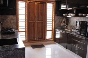 A modern kitchen with a double door, a gas stove, and a dishwasher. - Premium 2-Bedroom Apartment in Mysuru | Parking & WiFi (Mysuru)