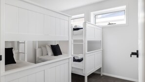 A room with white bunk beds, a window, and a door. - Three Bays Retreat- Pet Friendly (Nelson Bay)