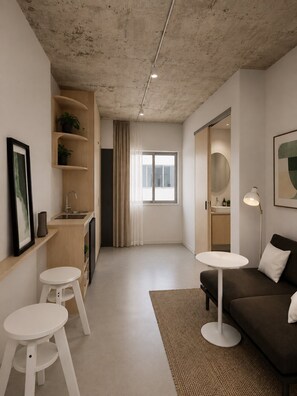 Ein modernes Interieur mit einer Küchenzeile, einem Sofa, einem Esstisch und einem großen Fenster.