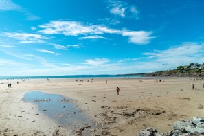 A wide sandy beach with scattered rocks and a clear blue sky. - L'Horizon de Pentrez -charmant duplex proche plage (Saint-Nic)
