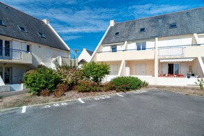 A residential area with two-story houses, a clear sky, and a parking area. - L'Horizon de Pentrez -charmant duplex proche plage (Saint-Nic)