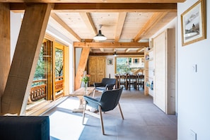 A wooden interior with a dining area, a chair, and a table. - L'atelier - stations de ski à 10 min de voiture (Fontcouverte-la-Toussuire)