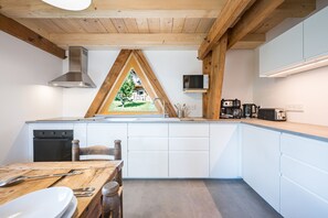 Ett modernt kök med en inbyggd ugn, en mikrovågsugn och en kaffebryggare.