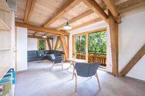 A spacious room with a high ceiling, wooden beams, a large window, and a balcony. - L'atelier - stations de ski à 10 min de voiture (Fontcouverte-la-Toussuire)