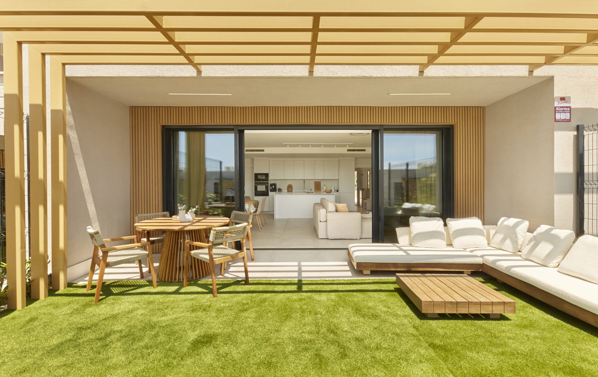 A modern outdoor living area with a dining set, a sofa, and a coffee table.