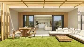 A modern outdoor living area with a dining set, a sofa, and a coffee table.