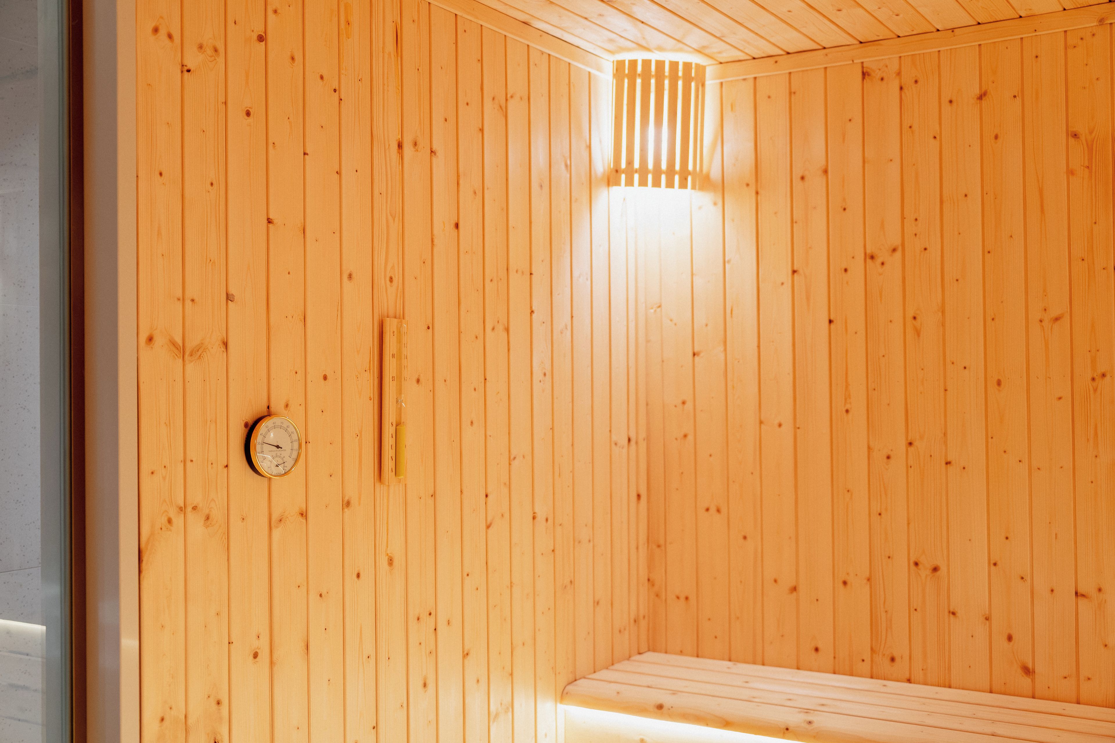 A sauna room with wooden walls and a bench.
