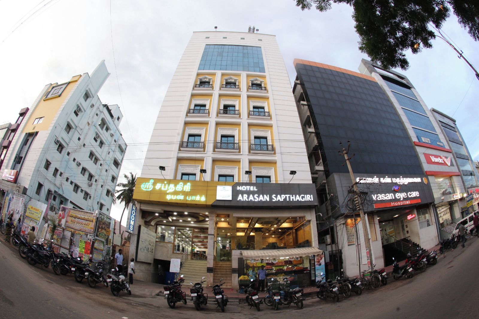 Een hotel genaamd 'Arasan Sapthagiri' met een moderne gevel, meerdere verdiepingen en een duidelijke entree.