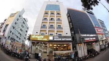 Een hotel genaamd 'Arasan Sapthagiri' met een moderne gevel, meerdere verdiepingen en een duidelijke entree.