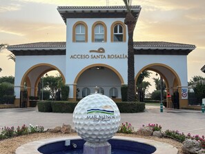 A golf ball in a fountain with a building labeled 'Acceso Santa Rosalía' in the background.