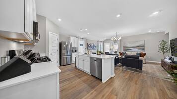 A modern kitchen with white cabinetry, stainless steel appliances, and a central island.