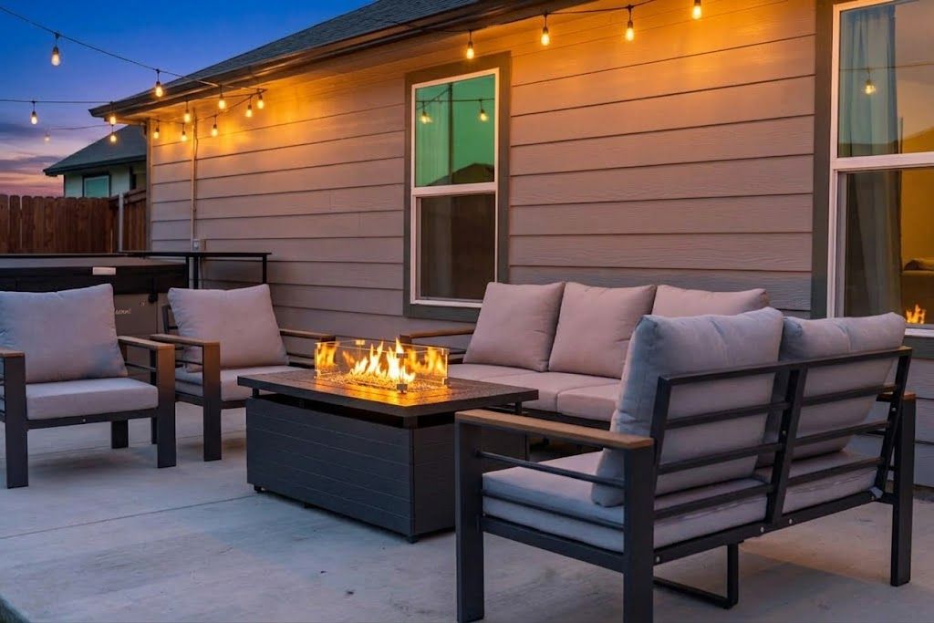 Un espacio al aire libre con asientos, una chimenea y una mesa.