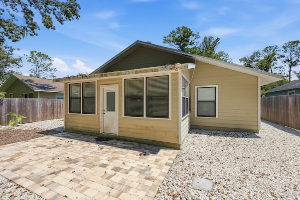 A single-story house with a front porch, a door, and windows.