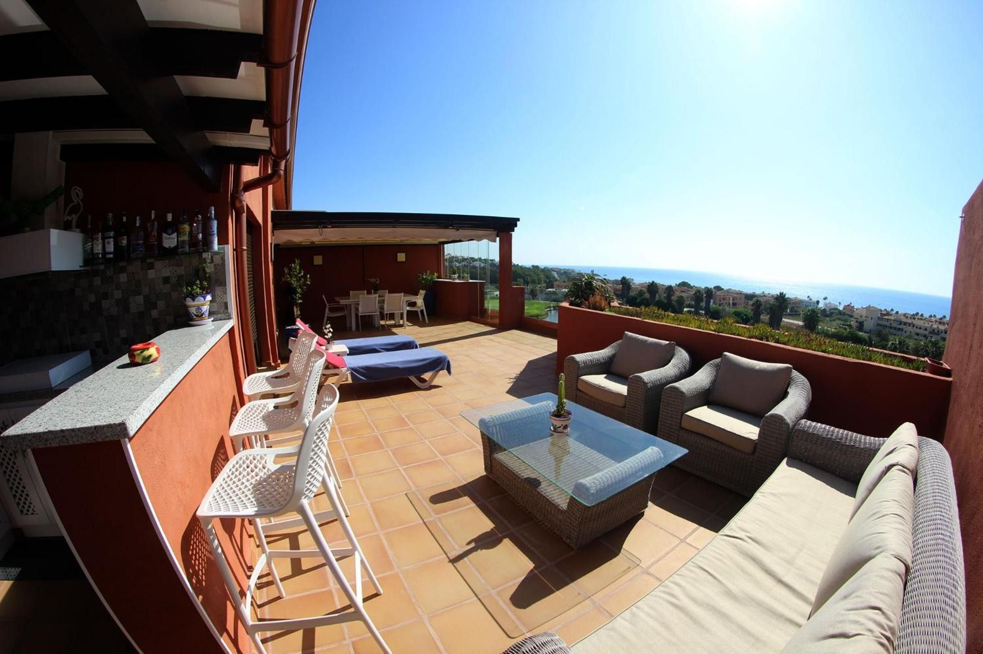 Une terrasse avec mobilier d’extérieur, un espace bar et une vue sur la mer.