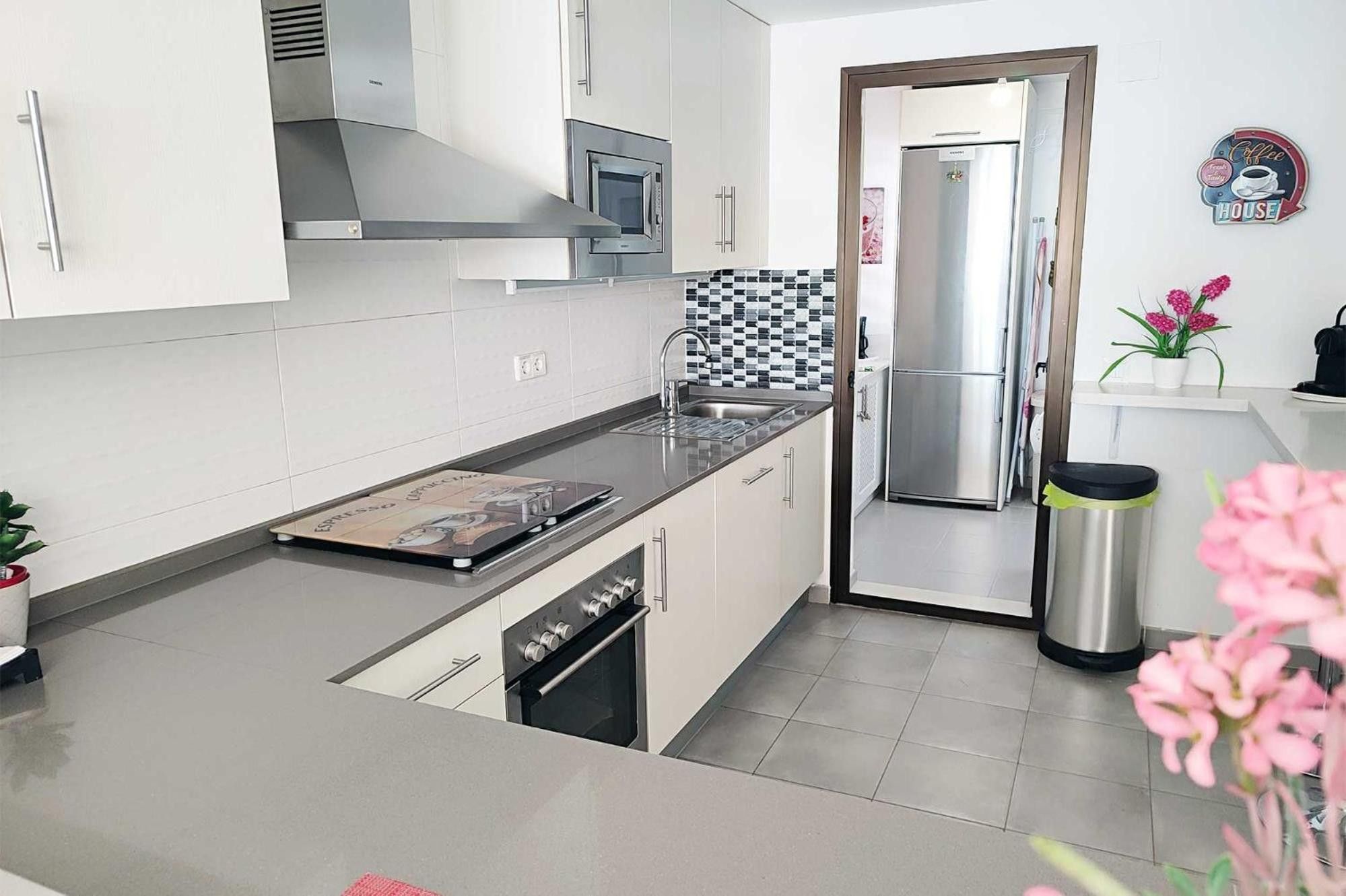 A modern kitchen with stainless steel appliances, a microwave, and a refrigerator.